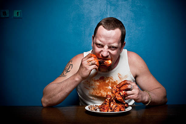 Big hungry muscular man eating meat - grilled chicken